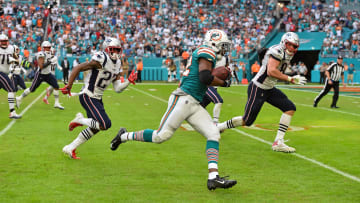 Miami Dolphins running back Kenyan Drake (32) completes the "Miami Miracle" when he runs past Rob Gronkowski on the final play against the New England Patriots in a December 2018 game.