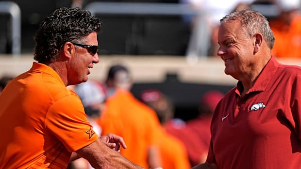 Oklahoma State coach Mike Gundy shakes hands with Arkansas coach Sam Pittman