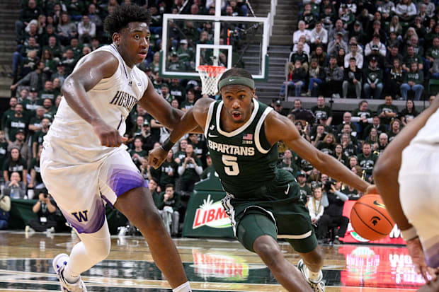 Michigan State Spartans guard Tre Holloman (5) drives past Washington Huskies forward Great Osobor (1).