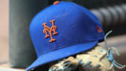 Jul 13, 2022; Atlanta, Georgia, USA; A detailed view of a New York Mets hat and glove in the dugout against the Atlanta Braves in the eighth inning at Truist Park. 