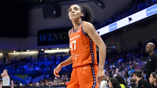 Connecticut Sun guard Leila Lacan looks at the scoreboard while wearing an orange jersey