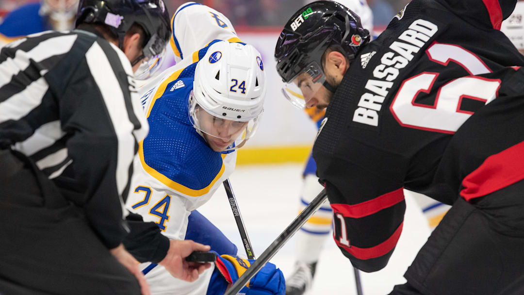 Nov 16, 2022; Ottawa, Ontario, CAN; Buffalo Sabres center Dylan Cozens (24) faces off  against Ottawa Senators center Derick Brassard (61) in the first period at the Canadian Tire Centre. Mandatory Credit: Marc DesRosiers-Imagn Images