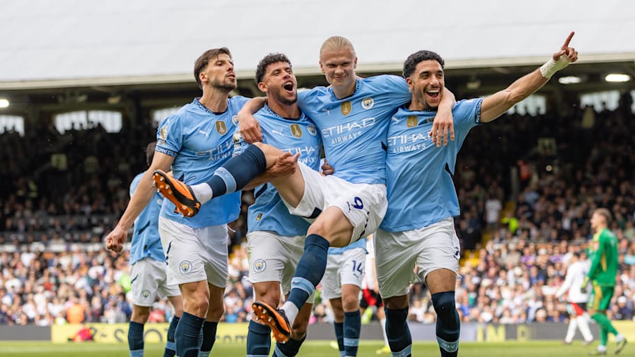 Erling Haaland being lifted up by his Manchester City teammates.
