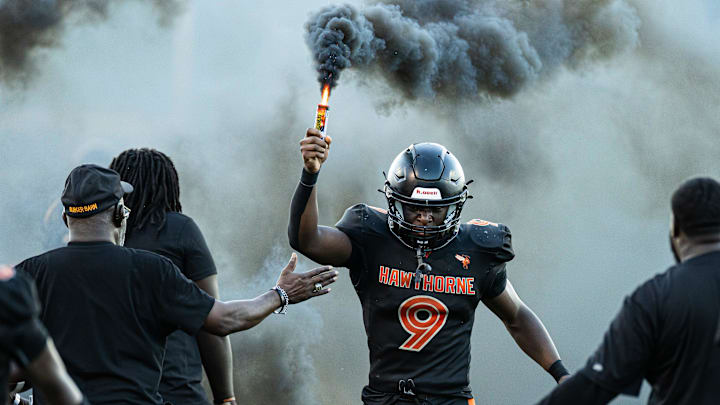 Hawthorne Hornets running back Kenoon Johnson (9) holds a smoke bomb before against the Newberry Panthers before the game at Hawthorne High School Football Stadium in Hawthorne, FL on Friday, August 30, 2024. [Matt Pendleton/Gainesville Sun]