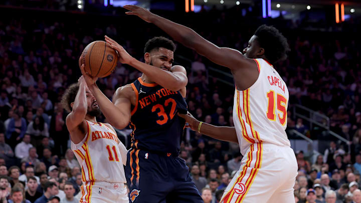 Dec 11, 2024; New York, New York, USA; New York Knicks center Karl-Anthony Towns (32) controls the ball against Atlanta Hawks guard Trae Young (11) and center Clint Capela (15) during the second quarter at Madison Square Garden. Mandatory Credit: Brad Penner-Imagn Images