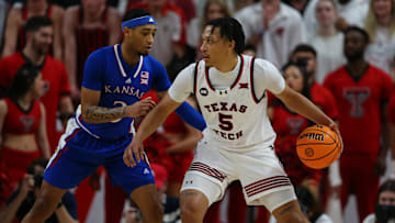 Feb 12, 2024; Lubbock, Texas, USA;  Texas Tech Red Raiders guard Darrion Williams (5) dribbles the ball against Kansas Jayhawks guard Dajuan Harris Jr (3) in the first half at United Supermarkets Arena. Mandatory Credit: Michael C. Johnson-Imagn Images