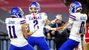 Dec 26, 2023; Phoenix, AZ, USA; Kansas Jayhawks wide receiver Lawrence Arnold (2) celebrates with wide receiver Luke Grimm (11) and wide receiver Quentin Skinner (0) during the second half against the UNLV Rebels in the Guaranteed Rate Bowl at Chase Field. Mandatory Credit: Mark J. Rebilas-USA TODAY Sports