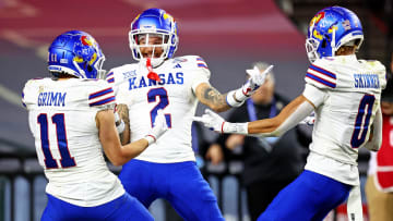 Dec 26, 2023; Phoenix, AZ, USA; Kansas Jayhawks wide receiver Lawrence Arnold (2) celebrates with wide receiver Luke Grimm (11) and wide receiver Quentin Skinner (0) during the second half against the UNLV Rebels in the Guaranteed Rate Bowl at Chase Field. Mandatory Credit: Mark J. Rebilas-USA TODAY Sports