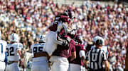 Texas A&M Aggies running back Amari Daniels (5) is lift into the air by offensive lineman Ar'maj Reed-Adams (55) in the first half of a game against the Samford Bulldogs at Kyle Field. 