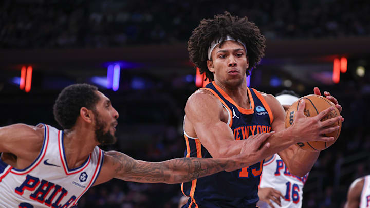 Mar 12, 2024; New York, New York, USA; New York Knicks center Jericho Sims (45) rebounds in front of Philadelphia 76ers guard Cameron Payne (22) during the second half at Madison Square Garden. Mandatory Credit: Vincent Carchietta-Imagn Images