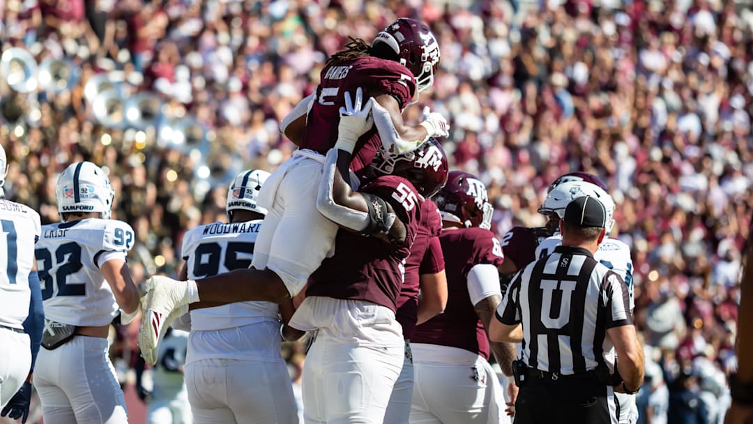 Nov 22, 2025; College Station, Texas, USA; Texas A&M Aggies running back Amari Daniels (5) is lift into the air by offensive lineman Ar'maj Reed-Adams (55) in the first half of a game against the Samford Bulldogs at Kyle Field. Mandatory Credit: Joseph Buvid-Imagn Images