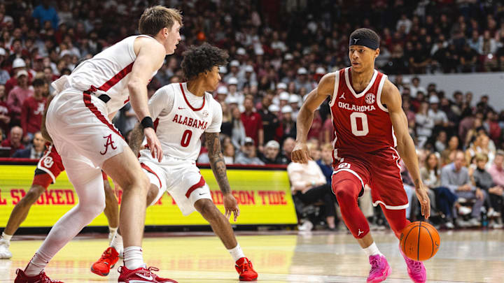 Jan 4, 2025; Tuscaloosa, Alabama, USA; Oklahoma Sooners guard Jeremiah Fears (0) drives the ball against Alabama Crimson Tide guard Labaron Philon (0) and forward Grant Nelson (4) during the first half at Coleman Coliseum. Mandatory Credit: Will McLelland-Imagn Images