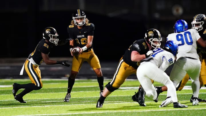 Oct 20, 2023; Carrollton, GA, USA; Carrollton Trojans quarterback Julian Lewis (10) hands-off against the Westlake Lions during the first half at Grisham Stadium. The 15-year-old Carrollton High student has already committed to playing for the University of Southern California Trojans and has been considered one of the top high school quarterback prospects. Mandatory Credit: John David Mercer-USA TODAY Sports