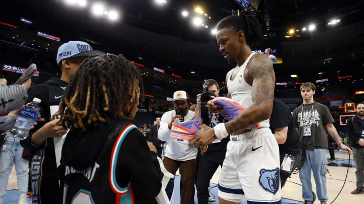 Jan 29, 2023; Memphis, Tennessee, USA; Memphis Grizzlies guard Ja Morant (12) gives is shoes to two fans after the game against the Indiana Pacers at FedExForum. 