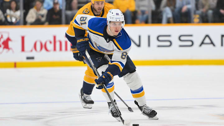 Mar 27, 2025; Nashville, Tennessee, USA;  St. Louis Blues center Dylan Holloway (81) skates with the puck against the Nashville Predators during the second period at Bridgestone Arena. Mandatory Credit: Steve Roberts-Imagn Images