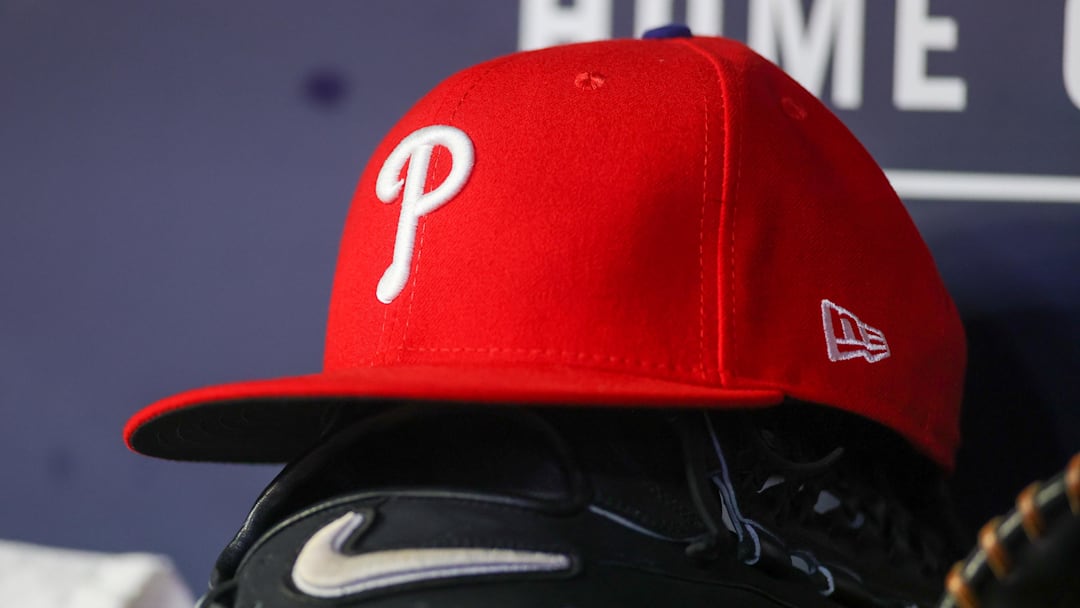 May 26, 2023; Atlanta, Georgia, USA; A detailed view of a Philadelphia Phillies hat and glove on the bench against the Atlanta Braves in the seventh inning at Truist Park. 