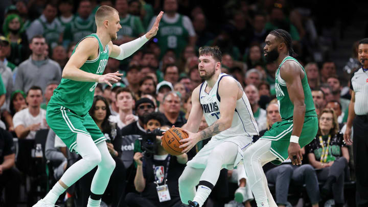 Jun 17, 2024; Boston, Massachusetts, USA; Dallas Mavericks guard Luka Doncic (77) controls the ball against Boston Celtics center Kristaps Porzingis (8) and guard Jaylen Brown (right) during the fourth quarter in game five of the 2024 NBA Finals at TD Garden. Mandatory Credit: Peter Casey-USA TODAY Sports