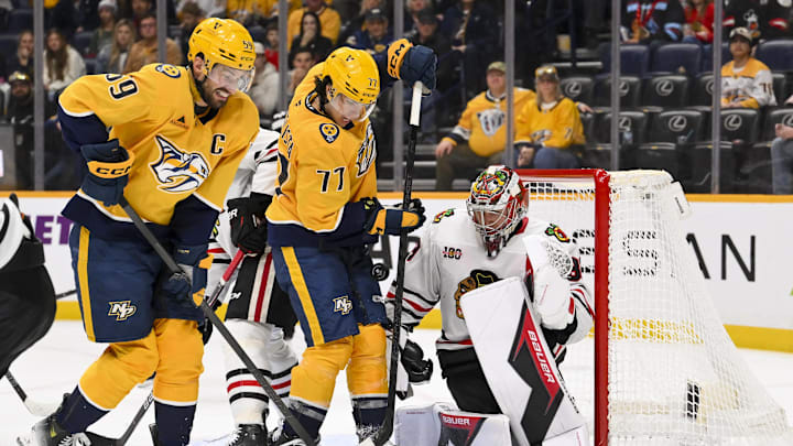 Jan 10, 2026; Nashville, Tennessee, USA;  Chicago Blackhawks goaltender Drew Commesso (33) blocks the shot of Nashville Predators right wing Luke Evangelista (77) during the third period at Bridgestone Arena. Mandatory Credit: Steve Roberts-Imagn Images