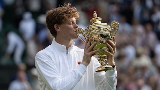 Jannik Sinner kisses the Wimbledon trophy