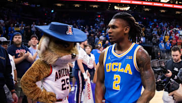 Dec 14, 2024; Phoenix, Arizona, USA; UCLA Bruins guard Dylan Andrews (2) celebrates as he walks past Arizona Wildcats mascot Wilbur following the game at Footprint Center. Mandatory Credit: Mark J. Rebilas-Imagn Images