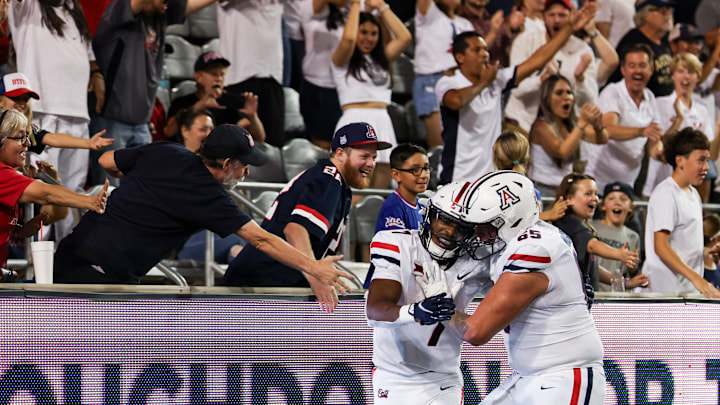 Aug 31, 2024; Tucson, Arizona, USA; Arizona Wildcats running back Jacory Croskey-Merritt (1) celebrates touchdown with fans and Arizona Wildcats offensive lineman Leif Magnuson during fourth quarter at Arizona Stadium. Mandatory Credit: Aryanna Frank-Imagn Images