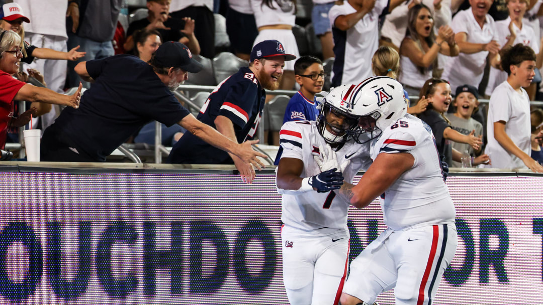 Aug 31, 2024; Tucson, Arizona, USA; Arizona Wildcats running back Jacory Croskey-Merritt (1) celebrates touchdown with fans and Arizona Wildcats offensive lineman Leif Magnuson during fourth quarter at Arizona Stadium. 