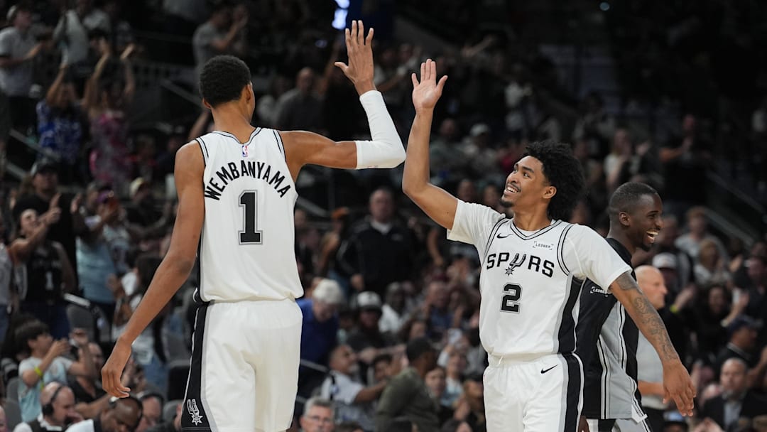 Oct 26, 2025; San Antonio, Texas, USA; San Antonio Spurs forward Victor Wembanyama (1) and guard Dylan Harper (2) celebrates in the second half against the Brooklyn Nets at Frost Bank Center. Mandatory Credit: Daniel Dunn-Imagn Images