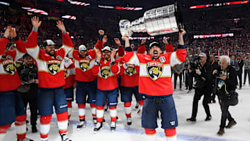 Brad Marchand holds the Stanley Cup trophy while his Florida Panthers teammates celebrate. 