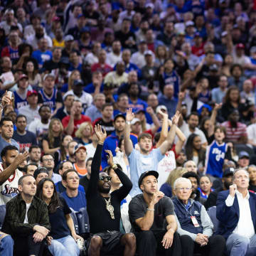 May 2, 2024; Philadelphia, Pennsylvania, USA; Philadelphia 76ers forward Nicolas Batum (40) shoots as musical artist Meek Mill (on left with sunglasses and neck jewelry) mimics his shooting action during the second half of game six of the first round for the 2024 NBA against the New York Knicks playoffs at Wells Fargo Center. Mandatory Credit: Bill Streicher-USA TODAY Sports