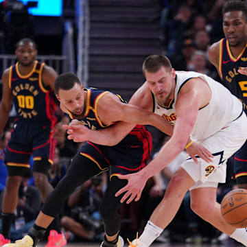 Apr 4, 2025; San Francisco, California, USA;  Golden State Warriors guard Stephen Curry (30) and Denver Nuggets center Nikola Jokic (15) chase the ball in the third period at Chase Center. Mandatory Credit: David Gonzales-Imagn Images