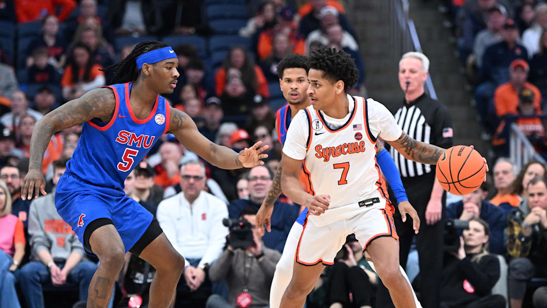 Feb 14, 2026; Syracuse, New York, USA; Syracuse Orange forward Kiyan Anthony (7) looks to get the ball past Southern Methodist University Mustangs guard Jaron Pierre Jr. (5) in the first half at the JMA Wireless Dome. Mandatory Credit: Mark Konezny-Imagn Images