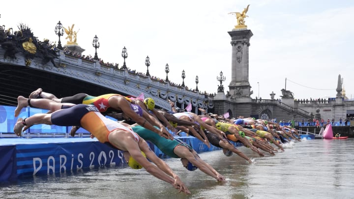 Jul 31, 2024; Paris, France; A general view as athletes dive into the Seine River at the start of the men's triathlon during the Paris 2024 Olympic Summer Games at Grand Palais-Pont Alexandre III.