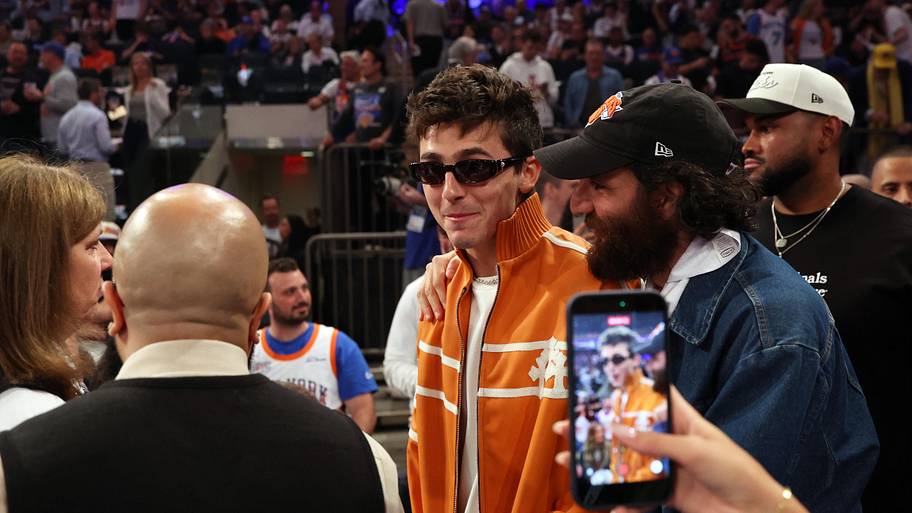 A fan takes a cellphone photo of actor Timothée Chalamet before game three of the 2026 NBA Finals.