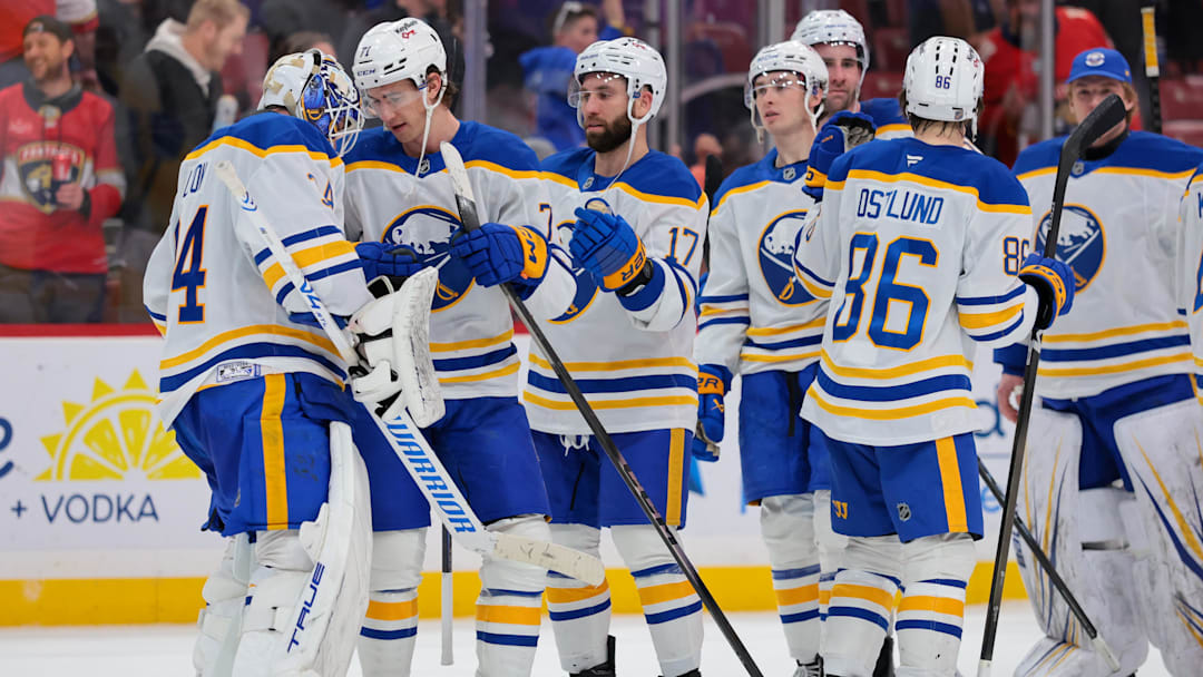 Buffalo Sabres players celebrate with goalie Alex Lyon
