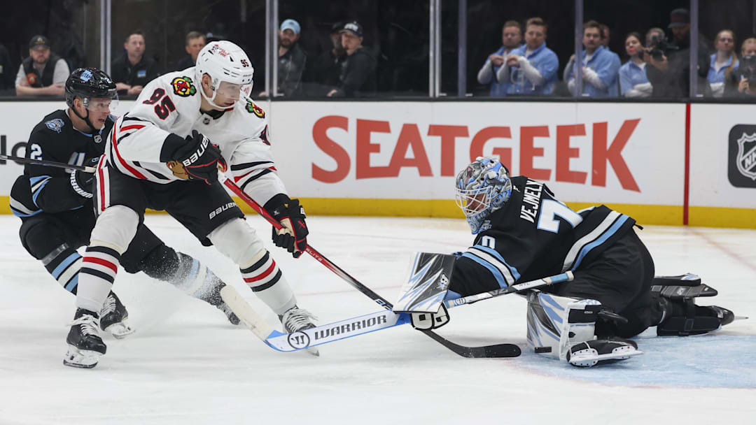 Feb 25, 2025; Salt Lake City, Utah, USA; Utah Hockey Club goaltender Karel Vejmelka (70) blocks the shot of Chicago Blackhawks right wing Ilya Mikheyev (95) during the second period at Delta Center. Mandatory Credit: Rob Gray-Imagn Images