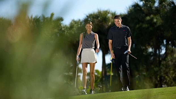 A man and woman model Reebok golf apparel.
