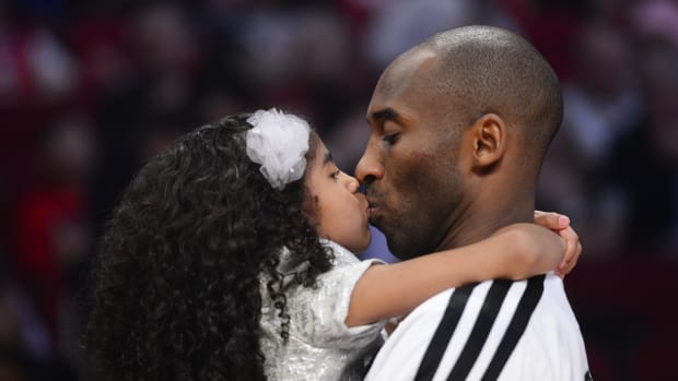 Kobe Bryant (right) of the Los Angeles Lakers kisses his daughter Natalia Bryant