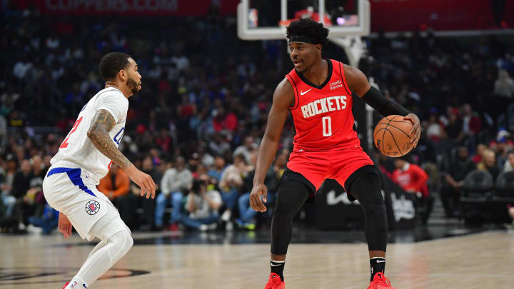 Apr 14, 2024; Los Angeles, California, USA; Houston Rockets guard Aaron Holiday (0) moves the ball against Los Angeles Clippers guard Xavier Moon (22) during the first half at Crypto.com Arena. Mandatory Credit: Gary A. Vasquez-USA TODAY Sports