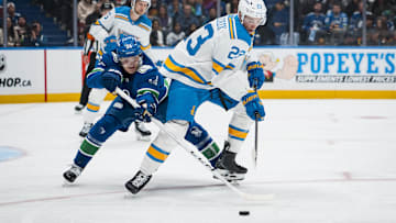 Oct 13, 2025; Vancouver, British Columbia, CAN; Vancouver Canucks forward Aatu Raty (54) stick checks St. Louis Blues defenseman Logan Mailloux (23) in the second period at Rogers Arena. Mandatory Credit: Bob Frid-Imagn Images