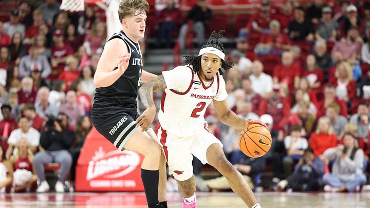 Nov 22, 2024; Fayetteville, Arkansas, USA; Arkansas Razorbacks guard Boogie Fland (2) drives against Little Rock Trojans guard Christian Hughes (0) during the second half at Bud Walton Arena. Arkansas won 79-67. Mandatory Credit: Nelson Chenault-Imagn Images