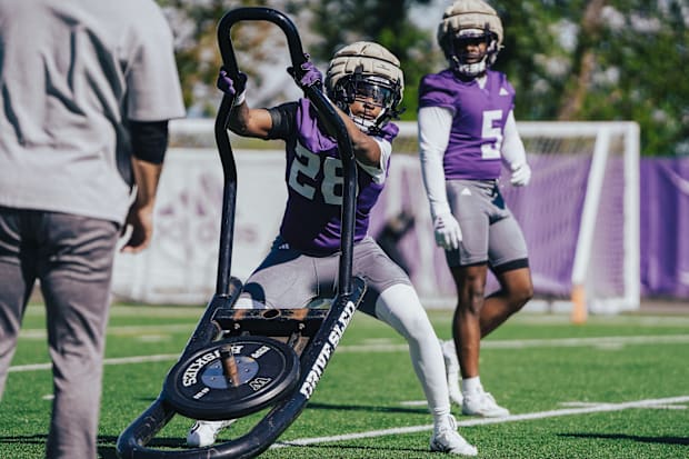 Freshman linebacker Khmori House works the sled during UW practice. 