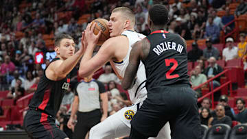 Mar 13, 2024; Miami, Florida, USA;  Denver Nuggets center Nikola Jokic (15) drives to the basket as Miami Heat guard Terry Rozier (2) and Miami Heat forward Nikola Jovic (5), right, defend during the first half at Kaseya Center. Mandatory Credit: Jim Rassol-Imagn Images