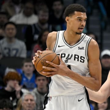 Feb 14, 2024; Dallas, Texas, USA; San Antonio Spurs center Victor Wembanyama (1) looks to move the ball past Dallas Mavericks guard Luka Doncic (77) during the fist quarter at the American Airlines Center. Mandatory Credit: Jerome Miron-USA TODAY Sports