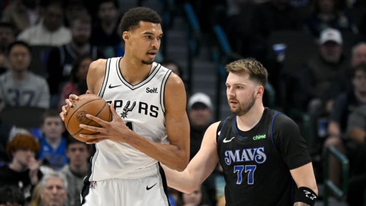 Feb 14, 2024; Dallas, Texas, USA; San Antonio Spurs center Victor Wembanyama (1) looks to move the ball past Dallas Mavericks guard Luka Doncic (77) during the fist quarter at the American Airlines Center. Mandatory Credit: Jerome Miron-USA TODAY Sports