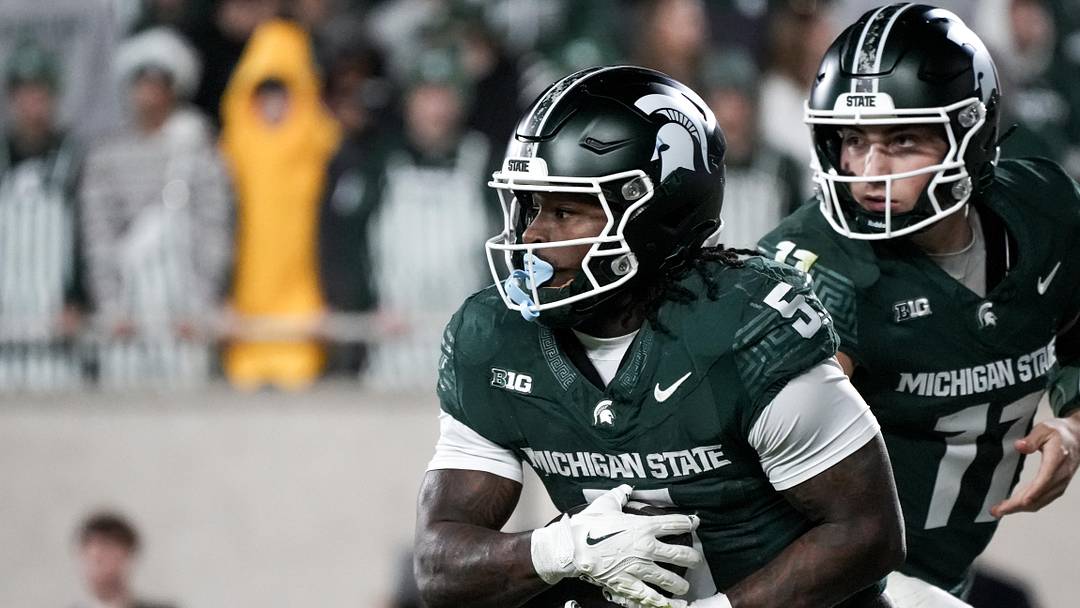 Nov 15, 2025; East Lansing, Michigan, USA; Michigan State quarterback Alessio Milivojevic (11) hands the ball off to Michigan State running back Makhi Frazier (5) against Penn State in the third quarter at Spartan Stadium. Mandatory Credit: Brendan Mullin-Imagn Images