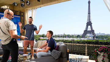 Former U.S. Olympian Michael Phelps and current U.S. Olympian Nic Fink, speak with a crew member. Go behind the scenes with NBC's TODAY show at the 2024 Paris Olympics.