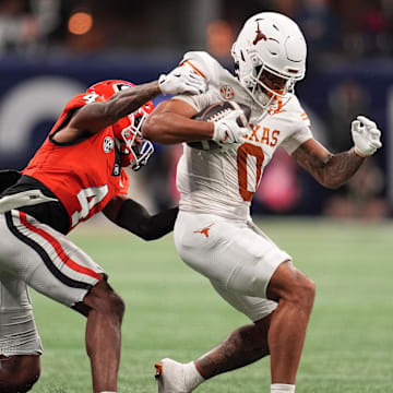 Dec 7, 2024; Atlanta, GA, USA; Georgia Bulldogs defensive back KJ Bolden (4) makes a tackle on Texas Longhorns wide receiver DeAndre Moore Jr. (0) during the first half in the 2024 SEC Championship game at Mercedes-Benz Stadium. Mandatory Credit: Dale Zanine-Imagn Images