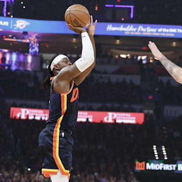 May 15, 2024; Oklahoma City, Oklahoma, USA;Oklahoma City Thunder guard Luguentz Dort (5) shoots a three-point basket as Dallas Mavericks guard Luka Doncic (77) defends during the first quarter of game five of the second round for the 2024 NBA playoffs at Paycom Center. Mandatory Credit: Alonzo Adams-Imagn Images