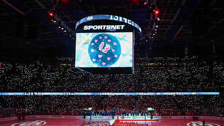 Dec 3, 2024; Calgary, Alberta, CAN; Johnny Gaudreau’s family on the ice during ceremonial puck drop by Columbus Blue Jackets center Sean Monahan (23) and Calgary Flames center Mikael Backlund (11) prior to the game between the Calgary Flames and the Columbus Blue Jackets at Scotiabank Saddledome. Mandatory Credit: Sergei Belski-Imagn Images