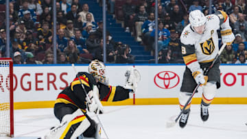 Apr 6, 2025; Vancouver, British Columbia, CAN; Vancouver Canucks goalie Kevin Lankinen (32) makes a save behind leaping Vegas Golden Knights forward Jack Eichel (9) in the third period at Rogers Arena. Mandatory Credit: Bob Frid-Imagn Images